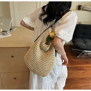 Vue détaillée d'un grand sac hobo en paille tressée avec bandoulière en cuir marron