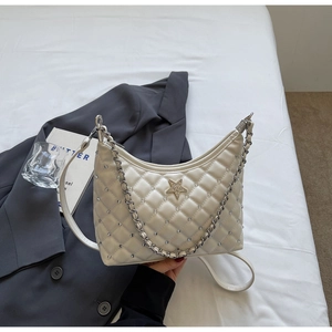 Détail du sac à bandoulière matelassé crème avec étoile en strass et chaîne