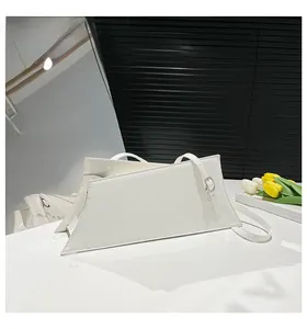 Detail of white asymmetric shoulder bag with glossy finish and silver buckle hardware