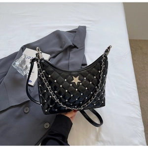 Détail du sac hobo matelassé noir avec emblème étoile argenté et bandoulière à chaîne