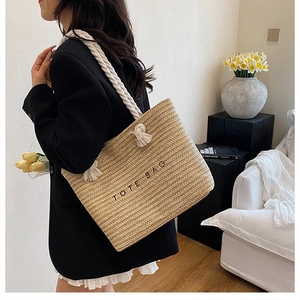 Detail showing woven straw texture and cotton rope handle of the stylish beach tote bag
