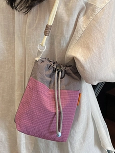Stylish patchwork drawstring crossbody bag in grey and pink gingham with rope strap