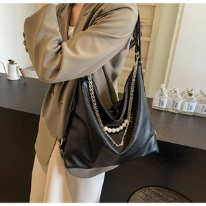 Détail du sac cabas en cuir noir avec poignée élégante en perles et chaîne en métal