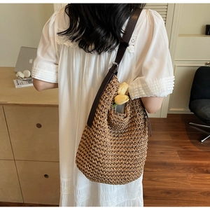 Détail d'un sac bandoulière en paille tressé à la main avec bandoulière en cuir brun