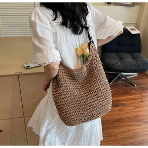 Détail du sac cabas en paille tissé à la main kaki avec finitions texturées et fleurs