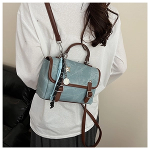 Detail view of teal messenger bag with GOTH FZDN engraving and decorative charms