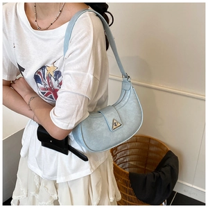 Detail view of light blue crescent underarm bag with marble texture and metal buckle
