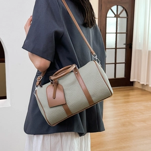 Detail of grey-green Boston bag with lychee grain leather and brown trim accents