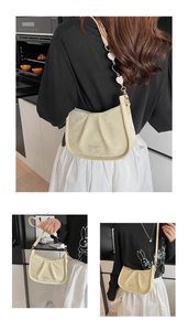 Détail montrant le sac plissé blanc crème avec breloque cœur en utilisation quotidienne