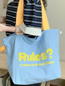 Blaue große Canvas-Tragetasche mit gelben Trägern und rebellischem Spruch-Aufdruck