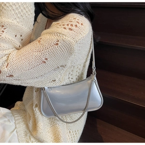 Détail du sac à bandoulière argenté métallisé avec chaîne sur un escalier