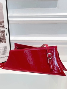 Chic red patent leather shoulder bag with asymmetrical shape and silver buckle detail