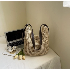 Détails d'un sac cabas en paille tressée avec anses en cuir marron et texture fine