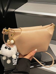 Chic beige ruched dumpling crossbody bag with cute fluffy plush charm and leather strap