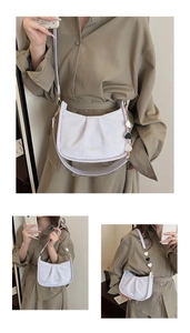 Détail du sac croissant lilas avec chaîne de cœurs et bandoulière porté par modèle
