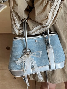 Chic light blue denim bucket bag with silver metallic trim and lace pearl bow charm