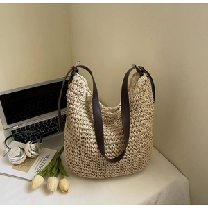 Détail du sac cabas en paille tissée avec bandoulière en cuir marron et doublure interne