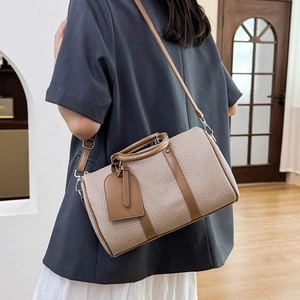 Close-up of beige lychee-pattern leather Boston bag with dark brown trim and top handle