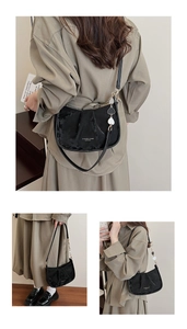 Détail du sac lune en velours noir avec breloque cœur et lettrage doré élégant