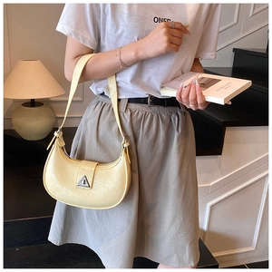 Detail of light yellow hobo bag featuring crinkled leather texture and silver buckle