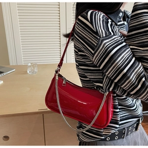 Mannequin portant un sac sous le bras en cuir verni rouge brillant avec chaîne argentée