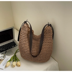 Vue détaillée de la texture tissée et des lanières en cuir marron foncé de ce sac de plage