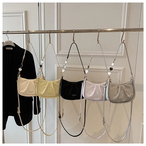 Détail de cinq sacs croissants plissés colorés avec breloques cœur sur une tige métallique