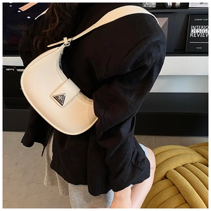 Close-up of off-white crescent bag with pleated leather texture and silver metal logo