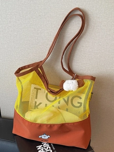 Contrast mesh tote bag in yellow and brown featuring a cute dog pattern and plush charm