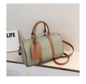 Detail of Boston bag with lychee texture leather, green body and brown trim