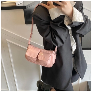 Close-up of pink glossy underarm bag with double front pockets on female model