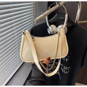 Détail du sac à bandoulière en cuir verni beige avec chaîne argentée et fermeture