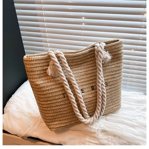Detailed macro view of woven straw texture with white rope handle and tassel decoration