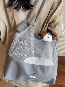Contrast mesh tote bag with cloud print and plush dog charm shown in lifestyle setting