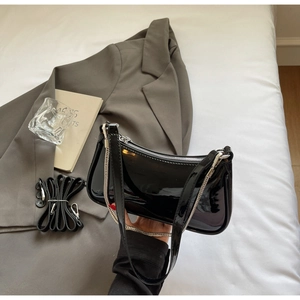 Détail du sac à main en cuir verni noir brillant avec fermeture éclair et bandoulière