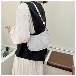 Détail du sac à bandoulière plissé gris clair avec boucles de sangle en forme de cœur