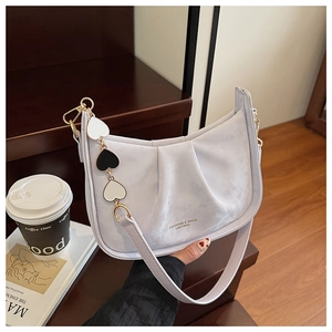 Détail du sac hobo lilas plissé avec pendentif cœur et logo doré sur le devant