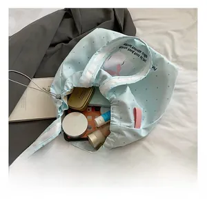 Internal capacity of light blue polka dot tote bag with drawstring and ample storage