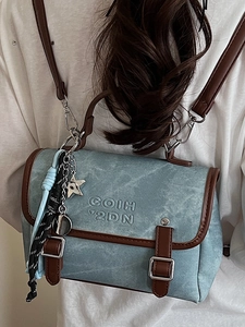 Vintage blue washed denim backpack with brown leather trim and metal star charm