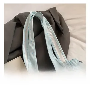 Close-up of comfortable reinforced handles on a blue polka dot tote bag with metal hardware