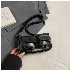 Detail of black glossy PU leather underarm bag with functional double front pockets
