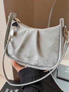 Sac bandoulière gris clair forme selle avec pendentif cœur et détails plissés