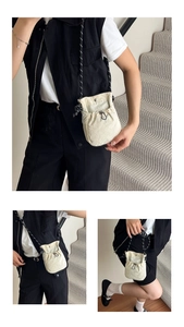 Détail du sac seau en nylon blanc cassé avec cordon de serrage et bouton pression en métal