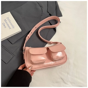 Pink minimalist baguette shoulder bag with dual front pockets and adjustable wide strap