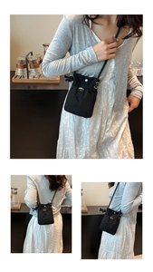 Détail du sac bandoulière en nylon noir avec cordon de serrage et bouton argenté