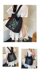 Detail of a black nylon tote bag with floral embroidery and a drawstring closure