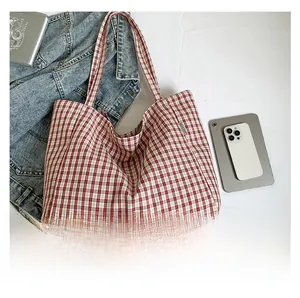 Vue à plat d'un cabas en toile à carreaux rouges et blancs avec veste en jean
