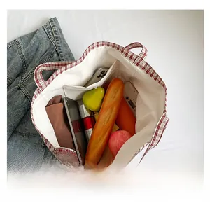 Détail de l'intérieur du grand sac fourre-tout à carreaux rouges avec poche latérale