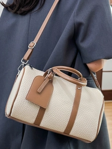 Minimalist beige and brown Boston leather handbag shown with a crossbody strap