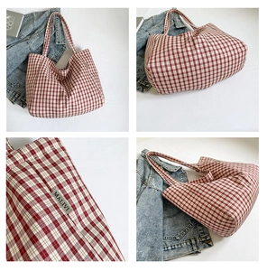 Vue détaillée du grand sac cabas en toile à carreaux rouges avec étiquette tissée de marque